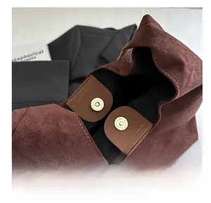 Dettaglio della borsa tote in pelle scamosciata marrone con chiusura magnetica dorata