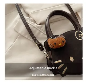 Detail of adjustable buckle and cute cat face embroidery on dark brown PU handbag