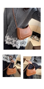 Detail of a brown leather shoulder bag with a silver bow and adjustable knotted strap