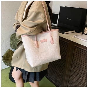 Close-up of pink tote bag featuring embossed cartoon patterns and fashion logo detail