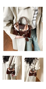 Detail of dark brown crocodile pattern handbag with golden buckle and fashion scarf wrap