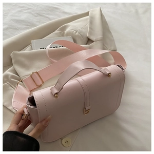 Close-up of pink crossbody bag with textured faux leather and gold metal hardware