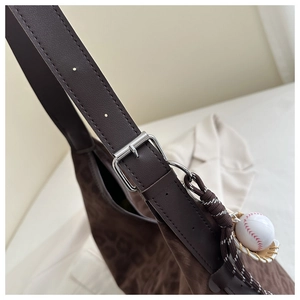Detailed close-up of leopard print tote strap with silver buckle and baseball charm