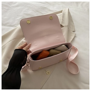 Internal view of light pink crossbody square bag showing storage for phone and wallet