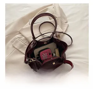 Deep red bucket bag interior showing spacious storage for makeup and wallet