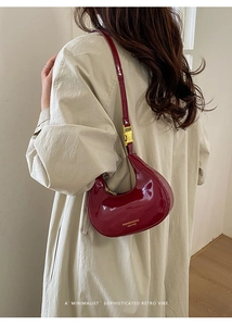 Dettaglio della borsa hobo a mezzaluna rosso vino in pelle verniciata lucida e fibbia