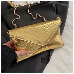 Detail of gold envelope bag with 3D water ripple texture and metallic bead chain strap