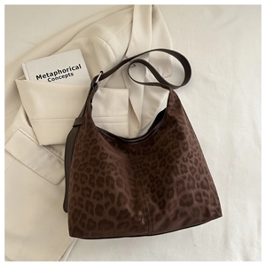 Close-up of leopard print hobo bag with a soft suede texture and wide shoulder strap