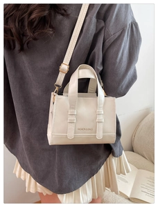 Detail shot of the white small tote bag featuring a textured finish and metallic hooks