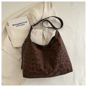 Close-up of leopard print suede hobo bag with adjustable strap and silver metal buckle