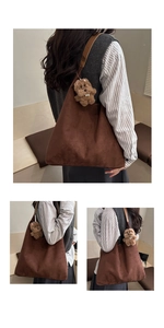 Detail of a large brown suede tote bag with a cute bear charm for daily commuting
