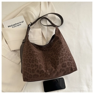 Detail of dark brown leopard print tote bag with matte texture and metal buckle