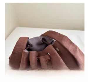 Dettaglio della borsa a coulisse in pelle scamosciata marrone con occhielli argentati e fodera