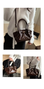 Detail of dark brown ruched bucket bag with glossy finish and gold metal buckle hardware