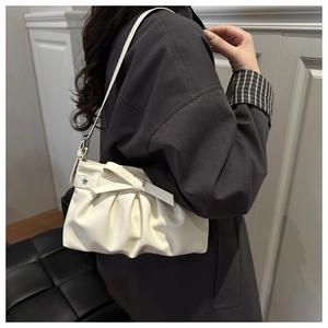 Dettaglio borsa sottobraccio plissettata bianco crema con fiocco e borchie a stella