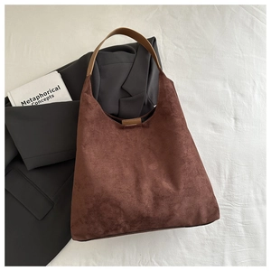 Close-up of brown suede hobo bag texture with a wide leather shoulder strap