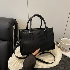 Borsa quadrata nera strutturata con texture verticale e anelli argento da donna
