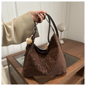 Close-up of leopard print tote bag with suede texture and baseball charm detail