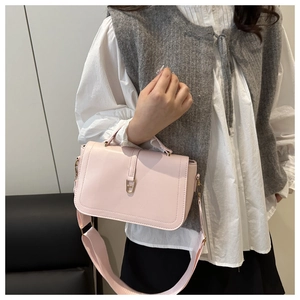 Detailed side view of pink leather shoulder bag with gold geometric metal clasp