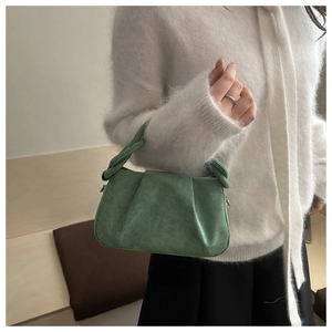 Dettaglio borsa a mano in pelle scamosciata verde con pieghe arricciate eleganti