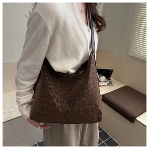 Detail of large leopard print tote bag worn over the shoulder for a chic winter commute