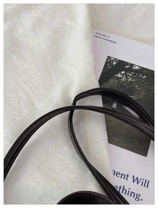 Close-up of premium black leather handle with detailed texture on a tote bag