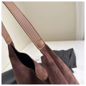 Macro detail of brown frosted suede tote bag with reinforced stitching and leather strap