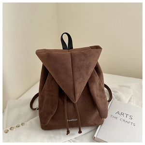 Detail shot of a dark brown suede backpack featuring cute rabbit ear lid and drawstrings