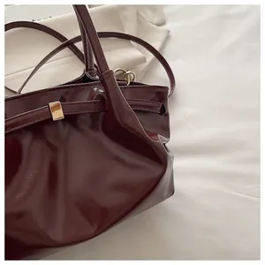 Detailed macro view of glossy burgundy leather texture with elegant gold buckle hardware