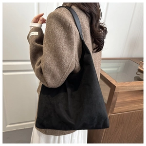 Dettaglio della borsa hobo in pelle scamosciata nera con tracolla in pelle liscia