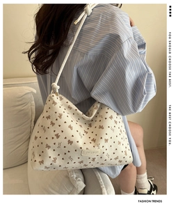 Corduroy shoulder bag featuring brown bow prints and leather brand tag shown on model