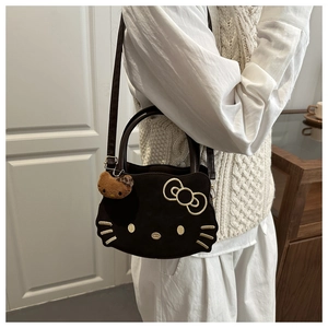 Detail of Hello Kitty crossbody bag with gold embroidery and leopard plush charm