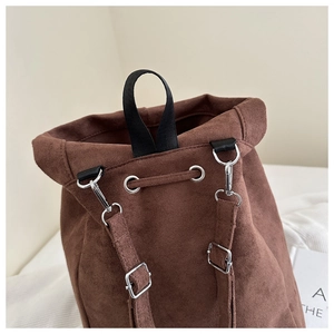 Detail of brown suede backpack with drawstring closure and silver metallic buckles