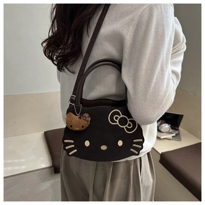 Detail view of brown cat-shaped handbag with embroidery and plush leopard charm