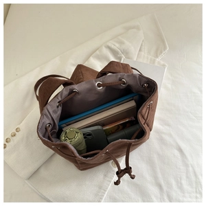 Spacious interior of brown corduroy bucket bag with drawstring and daily essentials