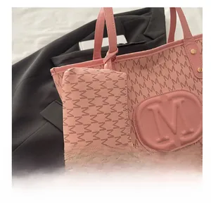 Detailansicht der rosa Tragetasche mit geprägtem M-Logo und Monogramm-Buchstabenmuster