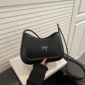 Minimalist black saddle shoulder bag with silver bow detail and pleated texture