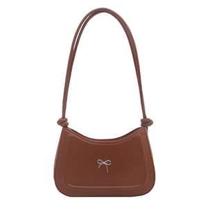 Caramel crescent shoulder bag with metallic bow detail and decorative knots on strap