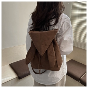Detail of a brown faux suede backpack with cute bunny ears and fashion print