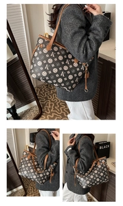 Détail du motif monogramme vintage et des lanières en cuir marron sur le grand sac cabas
