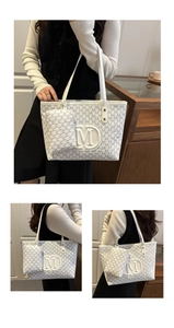 Detail der cremefarbenen Shopper-Tasche mit Monogramm-Print und kleiner Münztasche