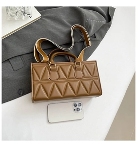 Brown quilted handbag with wide striped strap and smartphone for size reference