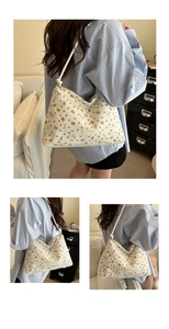 Detail of white corduroy tote bag with bow patterns, rope strap and fashion patch