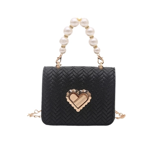 Minimalist black woven crossbody bag with gold heart clasp and pearl handle
