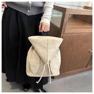 Dettaglio zaino in pelle scamosciata beige con orecchie di coniglio e chiusura a cordoncino