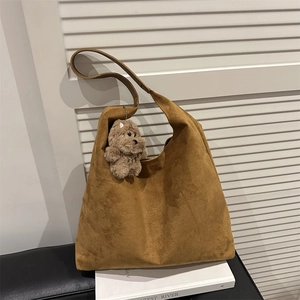 Retro brown suede hobo bag with plush puppy pendant shown on minimalist white background