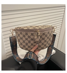 Detail der Vintage-Umhängetasche mit Ethno-Gurt und goldenen Metallbeschlägen am Halbmond-Bag