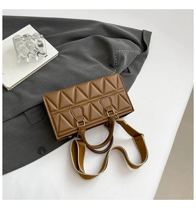 Macro shot of brown quilted leather texture and adjustable strap on the handbag