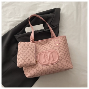Detail of pink monogram tote bag with embossed M logo and matching mini pouch set