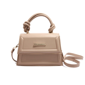 Elegant beige trapezoidal handbag with knotted handle and adjustable shoulder strap